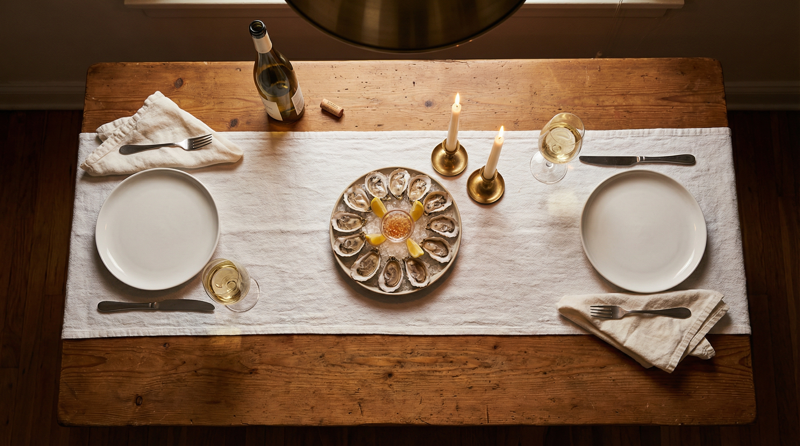 Romantic home setup with candles, wine and oysters